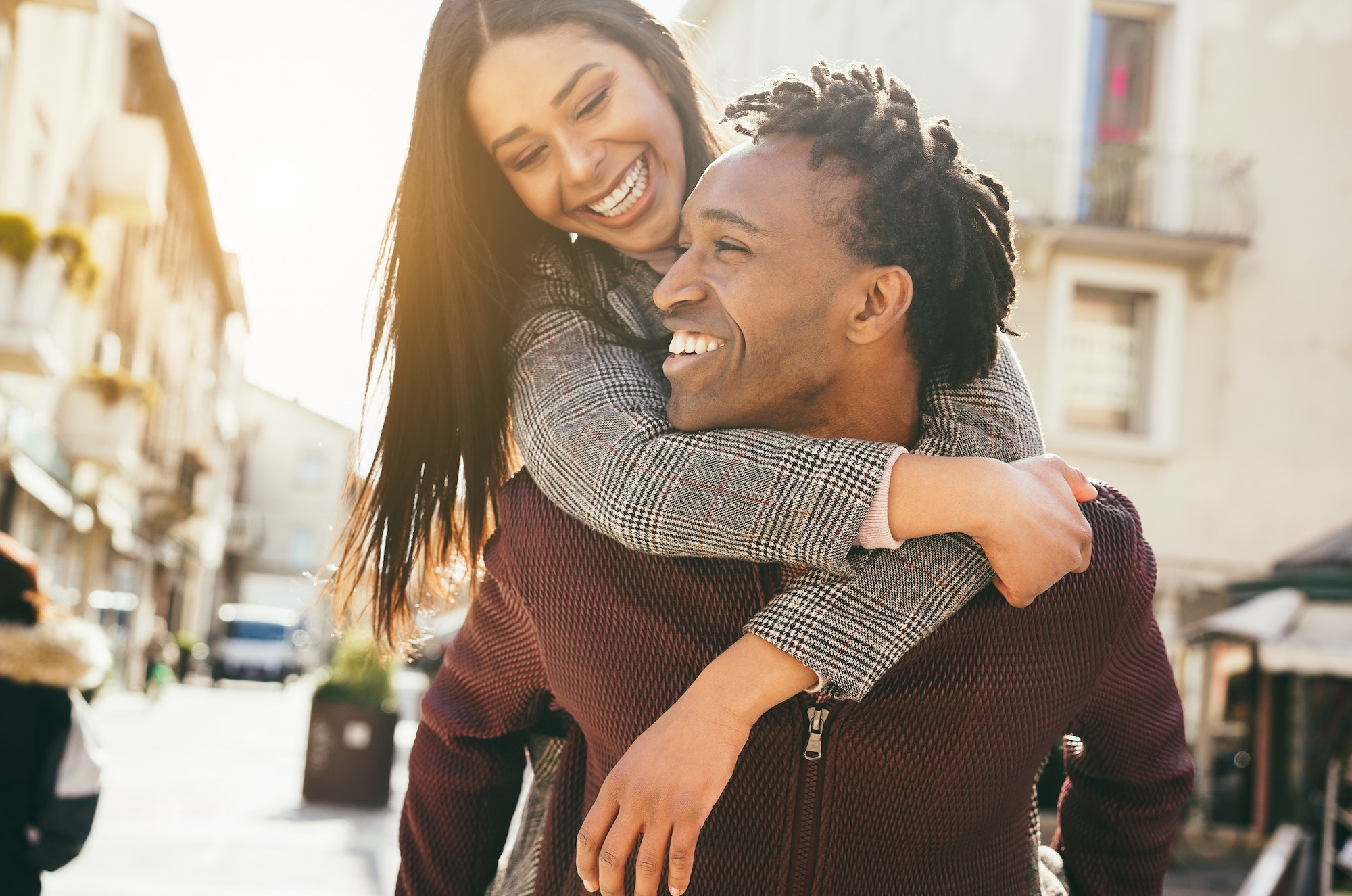 Young african couple having fun walking around the city - Main focus on man mouth